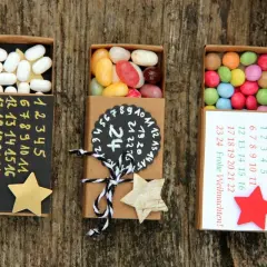 Kleine Schachteln zum Adventskalender to go basteln, gefüllt mit Süßigkeiten und nummerierten Tagen.