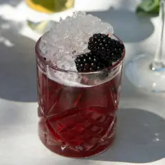 Ein erfrischender Drink mit zerstoßenem Eis und Brombeeren. Perfekt für einfache Cocktails an einem sonnigen Tag.