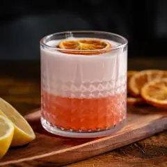 Erfrischender Aperol Sour mit Zitronenspalten und getrockneten Orangenscheiben. Ein tolles Aperol Sour Rezept für den Sommer.