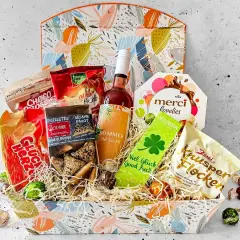 Ein liebevoll zusammengestellter Geschenkkorb zum 70. Geburtstag einer Frau, gefüllt mit Schokolade, Keksen, Wein und Glücksbringern.