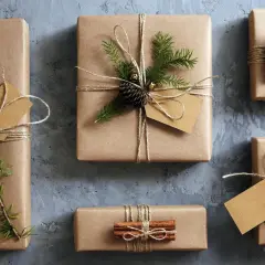 Geschenke mit Packpapier verpacken: liebevoll dekorierte Päckchen mit Tannenzweigen, Zapfen und Zimtstangen.