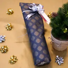 Eine **Flasche weihnachtlich verpacken** ist einfach mit diesem dunklen Geschenkpapier und silberner Schleife. Kleine Schleifen und ein Mini-Tannenbaum schmücken die Szene.