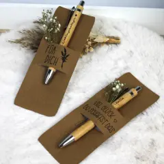Zwei liebevoll verpackte Stifte als Geschenk. Einer mit "Für dich" und der andere mit "Viel Glück du schaffst das" beschriftet, beide mit kleinen Blumen verziert.
