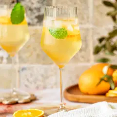 Erfrischender Lillet Spritz mit Eis, Minze und Orangenscheiben. Perfekt für einen sonnigen Nachmittag.