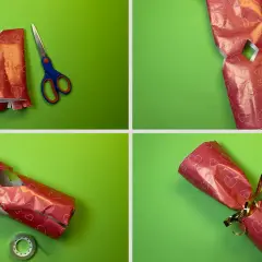 Schritt-für-Schritt-Anleitung: eine Kerze als Geschenk verpacken. Rotes Herz-Geschenkpapier wird zugeschnitten, gefaltet und mit Klebeband fixiert.
