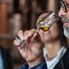 Mann mit Bart schnuppert an einem Grappa-Glas. So trinkt man Grappa: erst riechen, dann genießen.