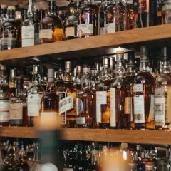 Regale voller Flaschen mit bernsteinfarbenem Whisky oder Whiskey. Eine große Auswahl für Kenner.