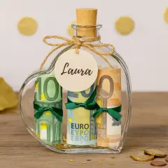 Herzförmige Glasflasche, gefüllt mit gerollten Euro-Scheinen, als kreative Möglichkeit, Geldgeschenke zu verpacken. Ein Anhänger mit dem Namen "Laura" ist angebracht.