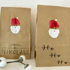 Zwei selbstgemachte Nikolauskarten aus Kraftpapier mit gemalten Nikolausgesichtern und Schriftzug "Vom Nikolaus" und "Ho Ho Ho".