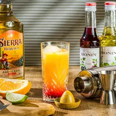 Für einen Tequila Sunrise welcher Tequila? Sierra Tequila Reposado, Orangensaft, Grenadine-Sirup und Limette sind bereit für den Drink.