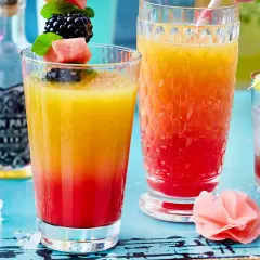 Zwei bunte Rum-Cocktails mit Früchten und Eis. Perfekt für easy Rum Cocktails an einem warmen Tag.