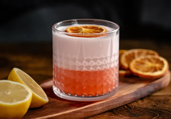 Erfrischender Aperol Sour mit Zitronenspalten und getrockneten Orangenscheiben. Ein tolles Aperol Sour Rezept für den Sommer.