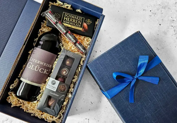 Ein edler Geschenkkorb zum 50. Geburtstag für einen Mann: Rotwein, dunkle Schokolade und Pralinen.