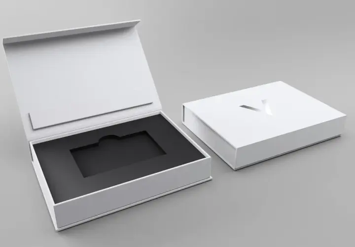Elegante weiße Geschenkbox mit schwarzem Inlay, ideal für Karten verpacken Ideen. Ein silbernes Logo ziert den Deckel.