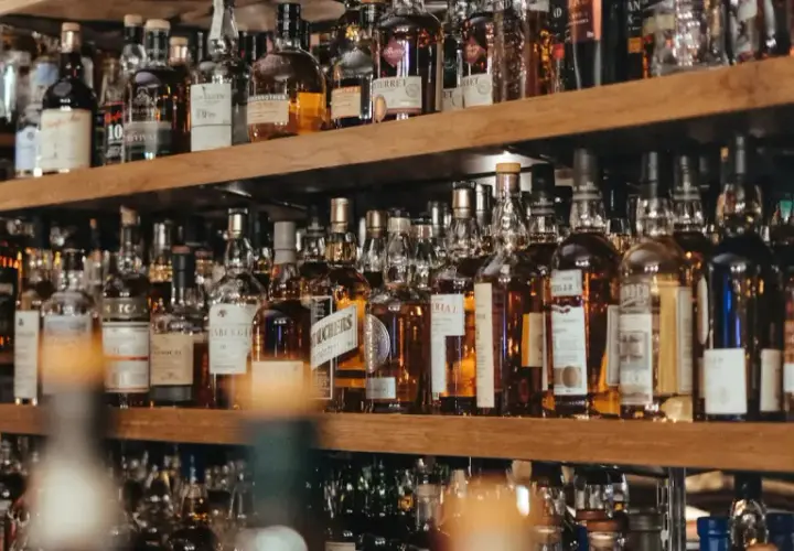 Regale voller Flaschen mit bernsteinfarbenem Whisky oder Whiskey. Eine große Auswahl für Kenner.