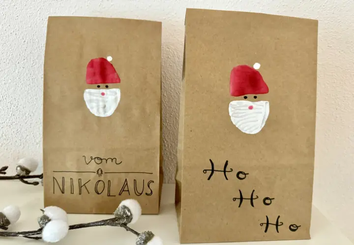 Zwei selbstgemachte Nikolauskarten aus Kraftpapier mit gemalten Nikolausgesichtern und Schriftzug "Vom Nikolaus" und "Ho Ho Ho".