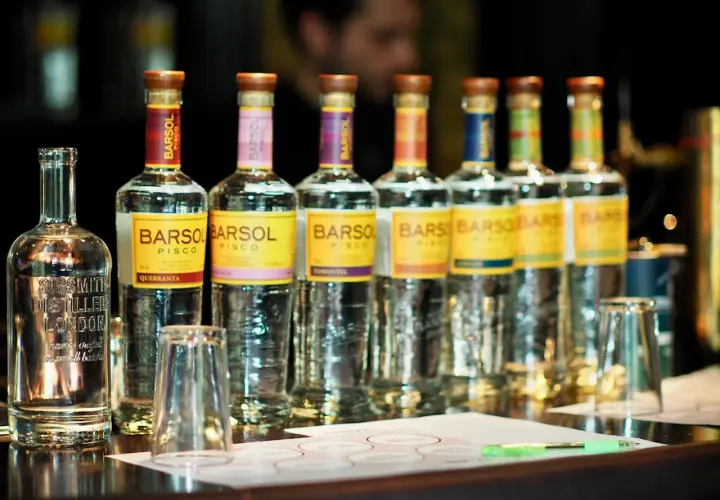 Mehrere Flaschen BARSOL Pisco stehen auf einer Theke, bereit für eine Verkostung. Was ist Pisco? Ein peruanischer Weinbrand.