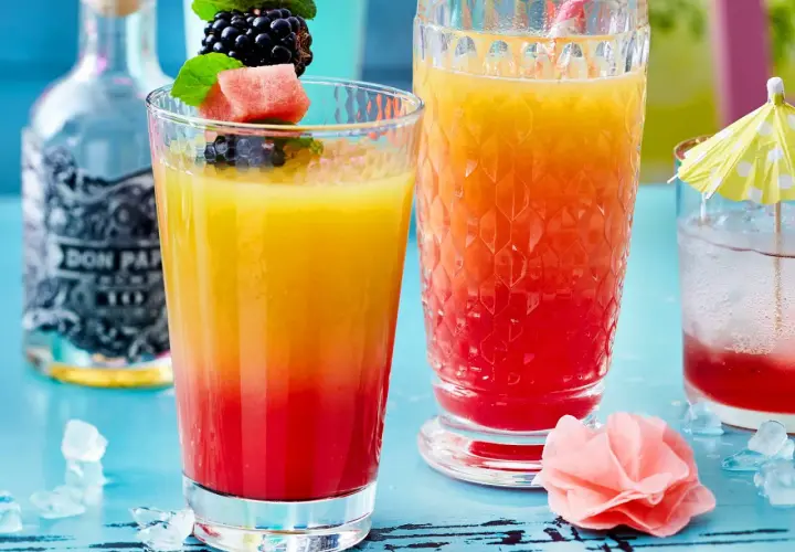 Zwei bunte Rum-Cocktails mit Früchten und Eis. Perfekt für easy Rum Cocktails an einem warmen Tag.