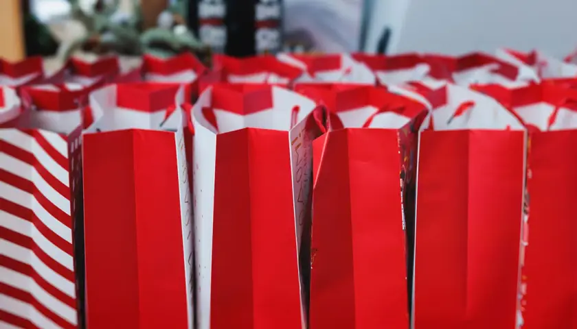 Viele rote Geschenktüten stehen bereit. Tolle Adventskalender Kolleg*innen Ideen für die Vorweihnachtszeit!