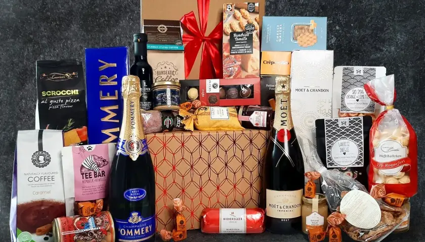 Ein üppiger Geschenkkorb zum 60. Geburtstag für einen Mann, gefüllt mit Champagner, Kaffee, Süßigkeiten und Delikatessen.