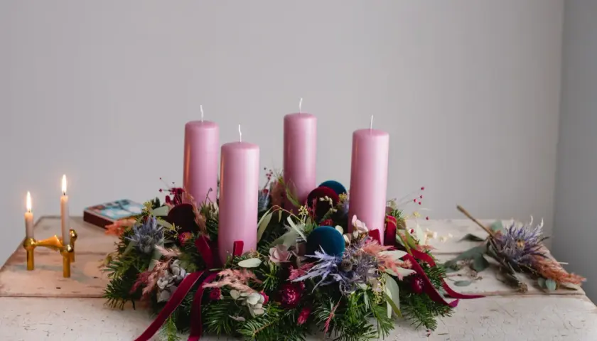 Ein wunderschöner Adventskranz natur selber machen: Tannengrün, rosa Kerzen, Beeren und Samtkugeln zieren diesen Kranz.