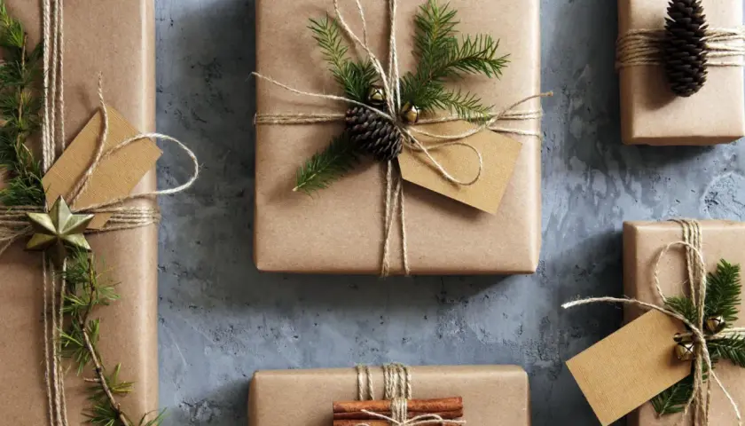 Geschenke mit Packpapier verpacken: liebevoll dekorierte Päckchen mit Tannenzweigen, Zapfen und Zimtstangen.