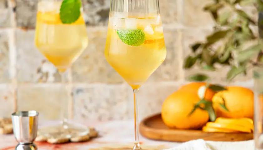 Erfrischender Lillet Spritz mit Eis, Minze und Orangenscheiben. Perfekt für einen sonnigen Nachmittag.