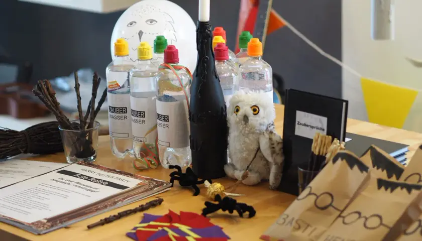 Harry Potter Geburtstag Ideen: Zauberwasser-Flaschen, Hedwig-Ballon, Zauberstäbe und eine Foto-Rallye für magische Momente.