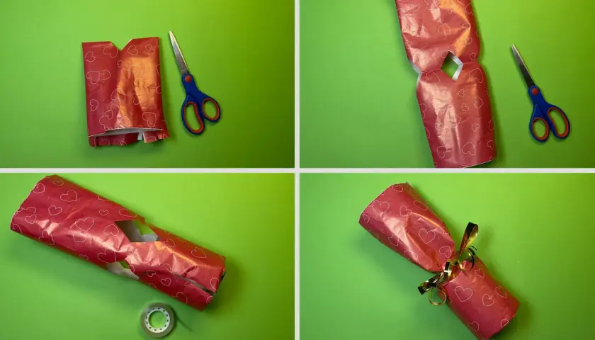 Schritt-für-Schritt-Anleitung: eine Kerze als Geschenk verpacken. Rotes Herz-Geschenkpapier wird zugeschnitten, gefaltet und mit Klebeband fixiert.