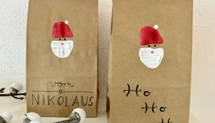 Zwei selbstgemachte Nikolauskarten aus Kraftpapier mit gemalten Nikolausgesichtern und Schriftzug "Vom Nikolaus" und "Ho Ho Ho".