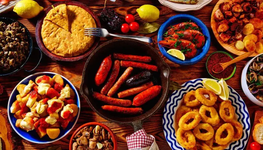 Vielfältige Tapas-Auswahl, perfekt für einen selbstgemachten Geschenkkorb: Chorizo, Garnelen, Calamari, Patatas Bravas und mehr.
