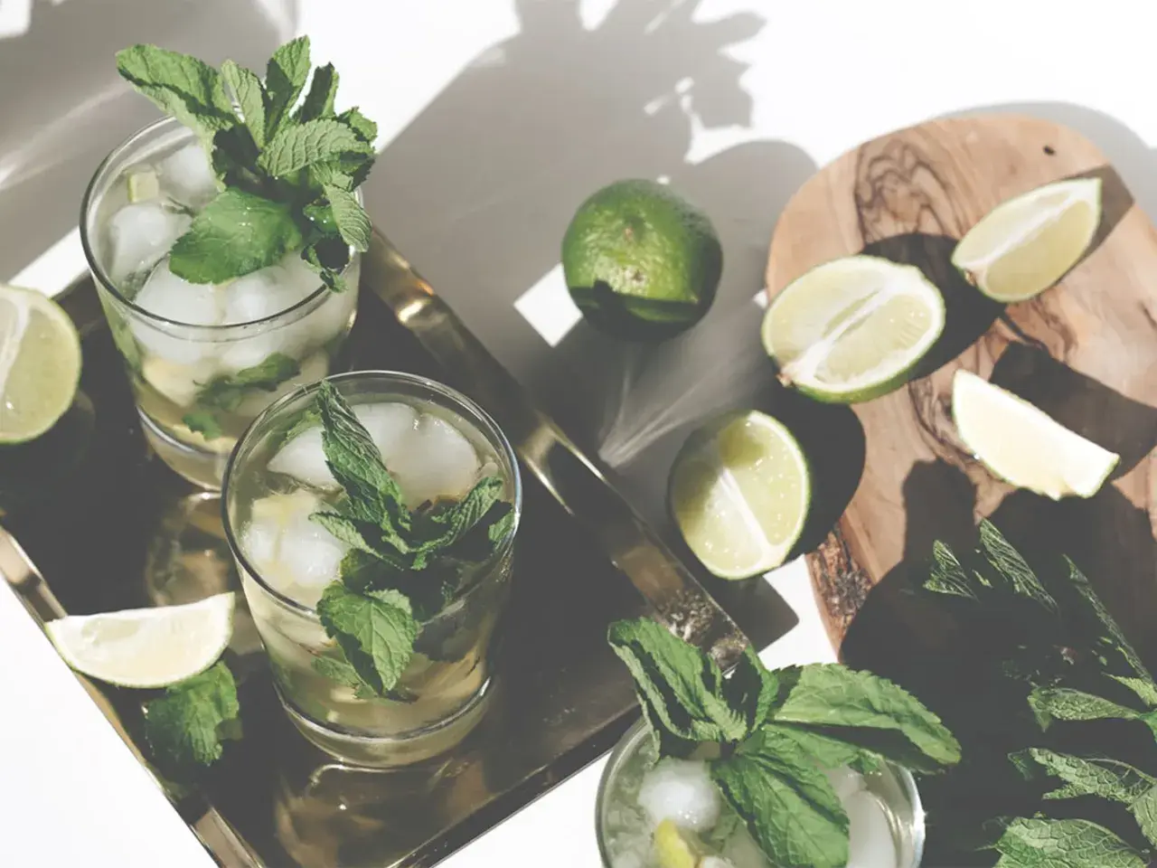 Erfrischender Mohito drink mit Limetten und Minze, serviert auf einem Tablett.