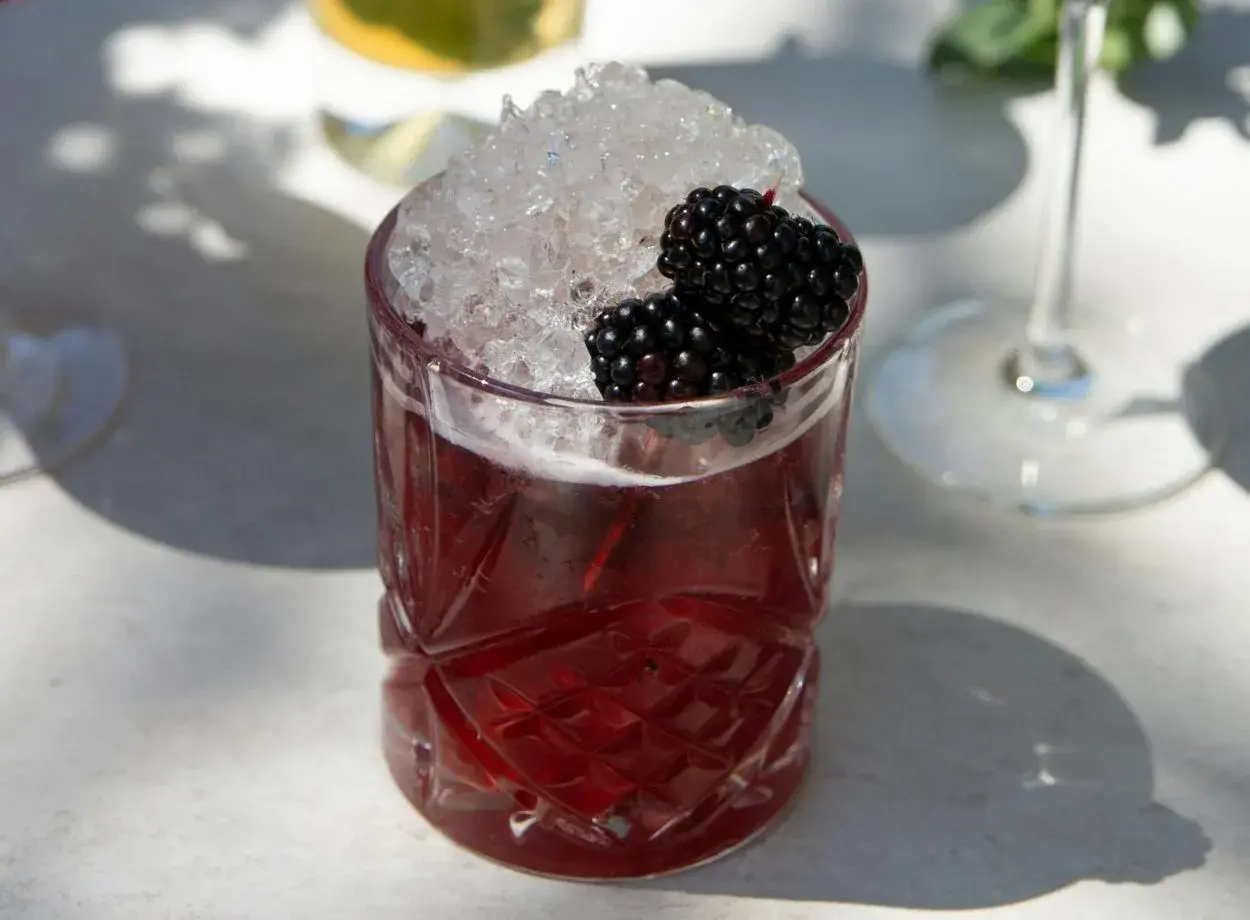 Ein erfrischender Drink mit zerstoßenem Eis und Brombeeren. Perfekt für einfache Cocktails an einem sonnigen Tag.