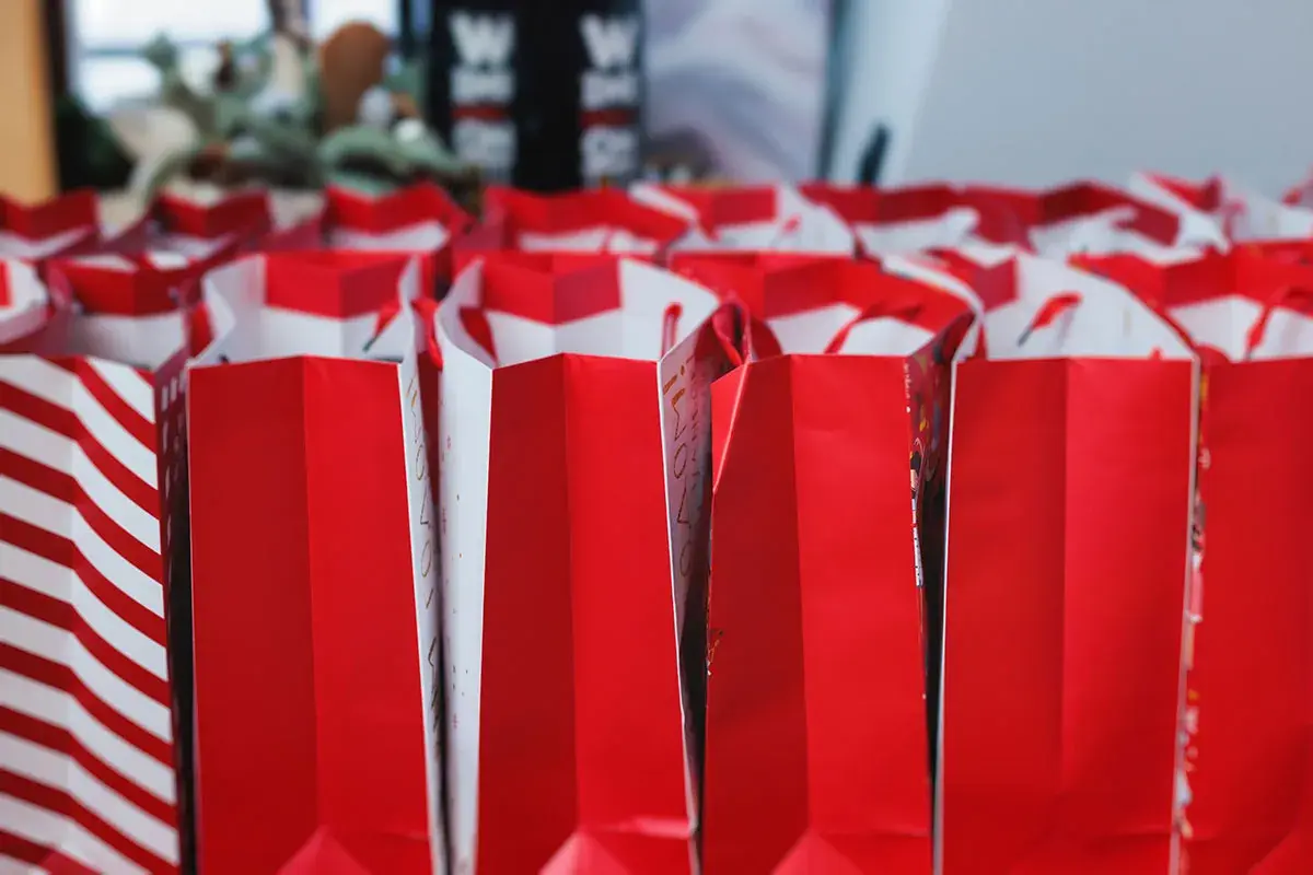 Viele rote Geschenktüten stehen bereit. Tolle Adventskalender Kolleg*innen Ideen für die Vorweihnachtszeit!