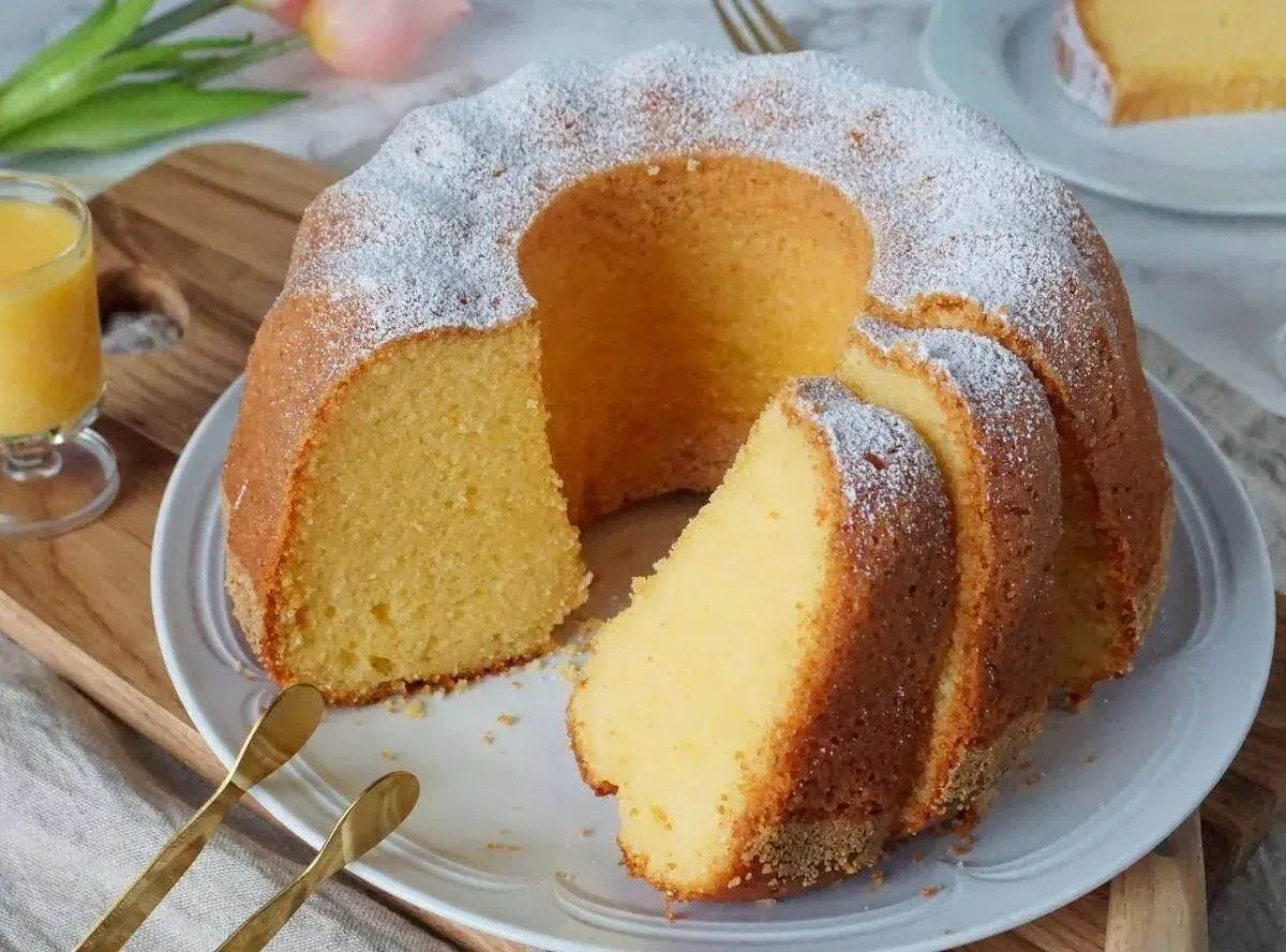 Saftiger Gugelhupf, bestäubt mit Puderzucker. Ein Stück dieses köstlichen alkohol kuchen wartet auf Sie.