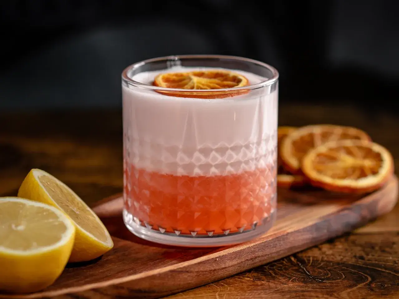 Erfrischender Aperol Sour mit Zitronenspalten und getrockneten Orangenscheiben. Ein tolles Aperol Sour Rezept für den Sommer.