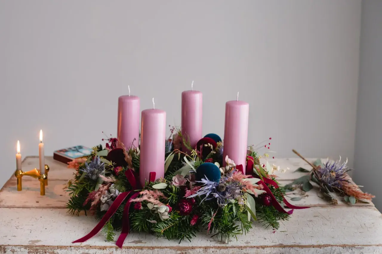 Ein wunderschöner Adventskranz natur selber machen: Tannengrün, rosa Kerzen, Beeren und Samtkugeln zieren diesen Kranz.