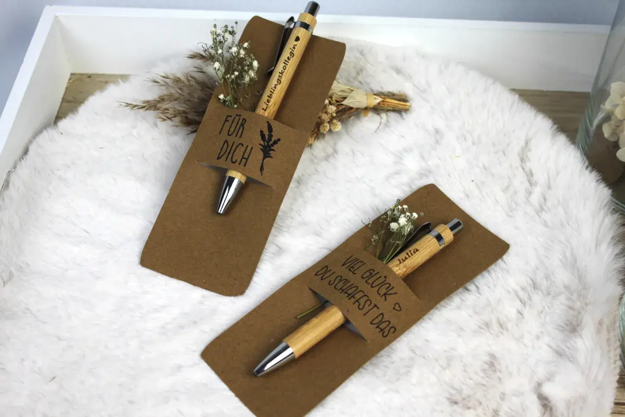 Zwei liebevoll verpackte Stifte als Geschenk. Einer mit "Für dich" und der andere mit "Viel Glück du schaffst das" beschriftet, beide mit kleinen Blumen verziert.