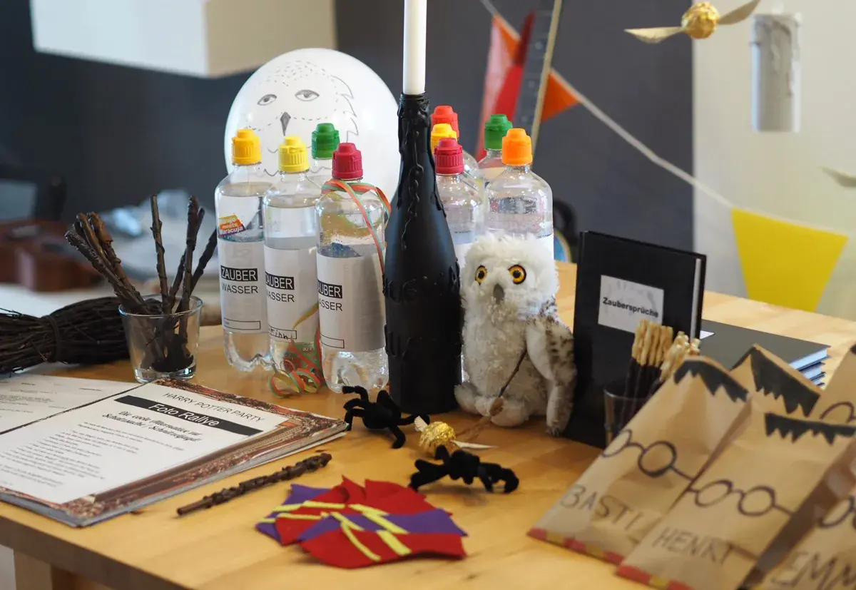 Harry Potter Geburtstag Ideen: Zauberwasser-Flaschen, Hedwig-Ballon, Zauberstäbe und eine Foto-Rallye für magische Momente.