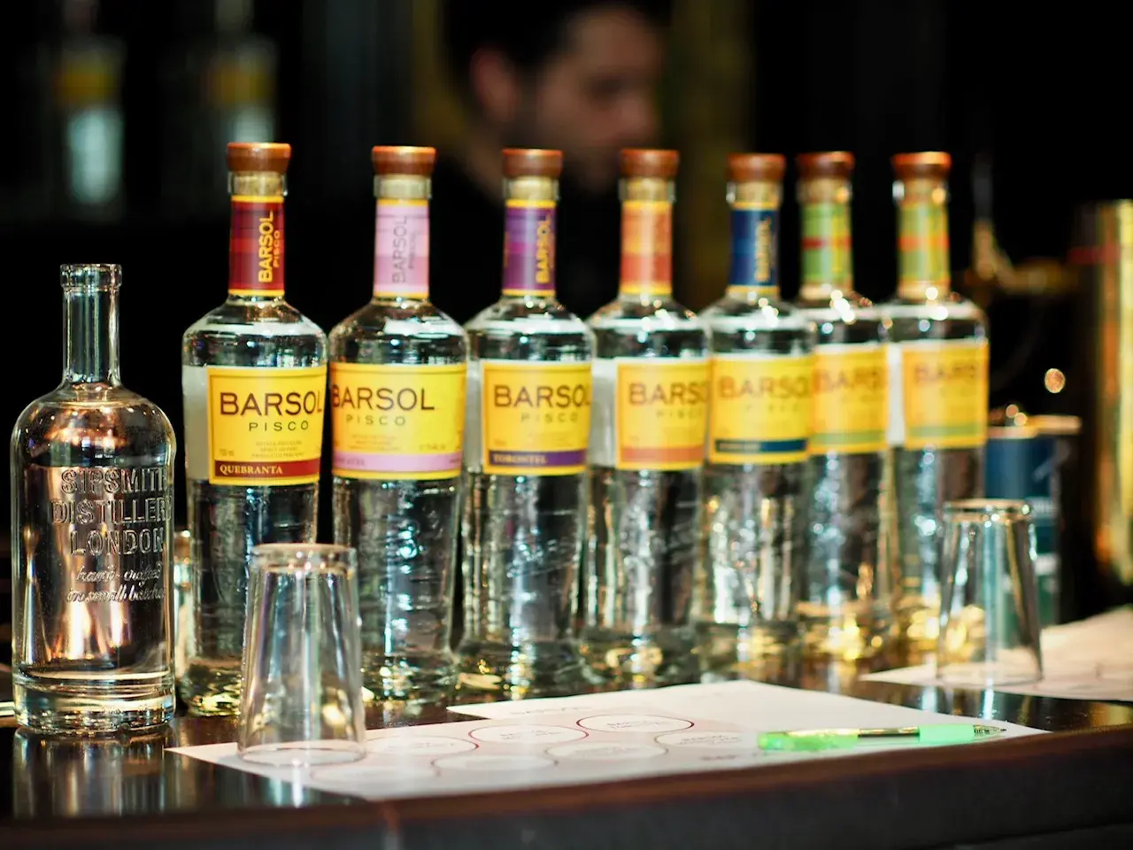 Mehrere Flaschen BARSOL Pisco stehen auf einer Theke, bereit für eine Verkostung. Was ist Pisco? Ein peruanischer Weinbrand.