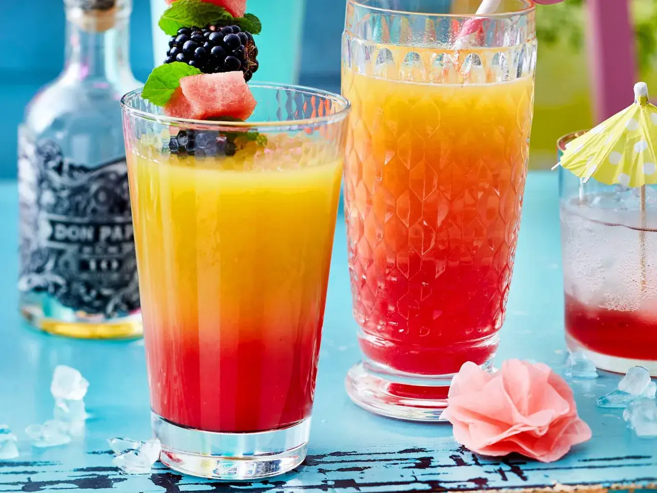 Zwei bunte Rum-Cocktails mit Früchten und Eis. Perfekt für easy Rum Cocktails an einem warmen Tag.