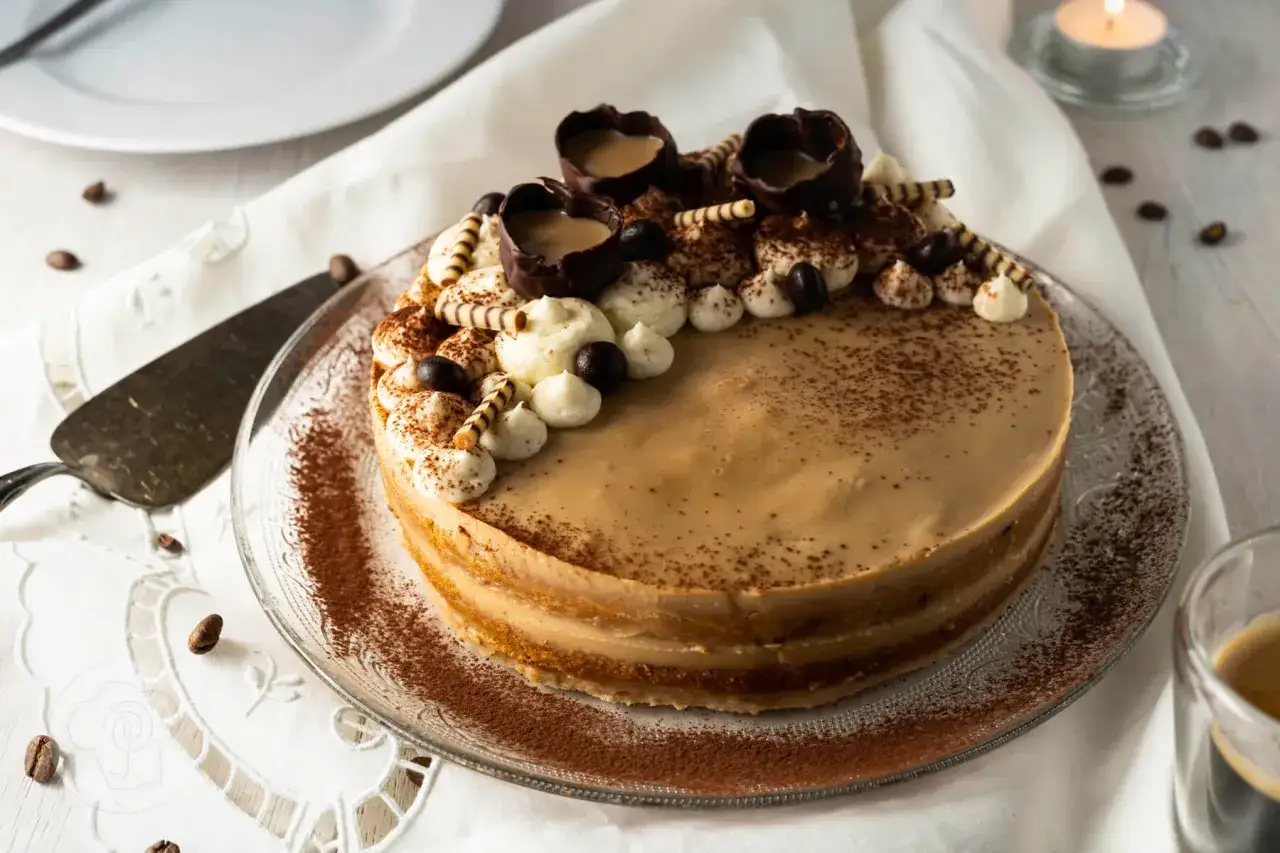 Ein köstlicher Kaffee-Kuchen, verziert mit Sahnetuffs, Schokoladenbechern und Kaffeebohnen. Ein Hauch von Alkohol macht diesen Kuchen zu einem Genuss.