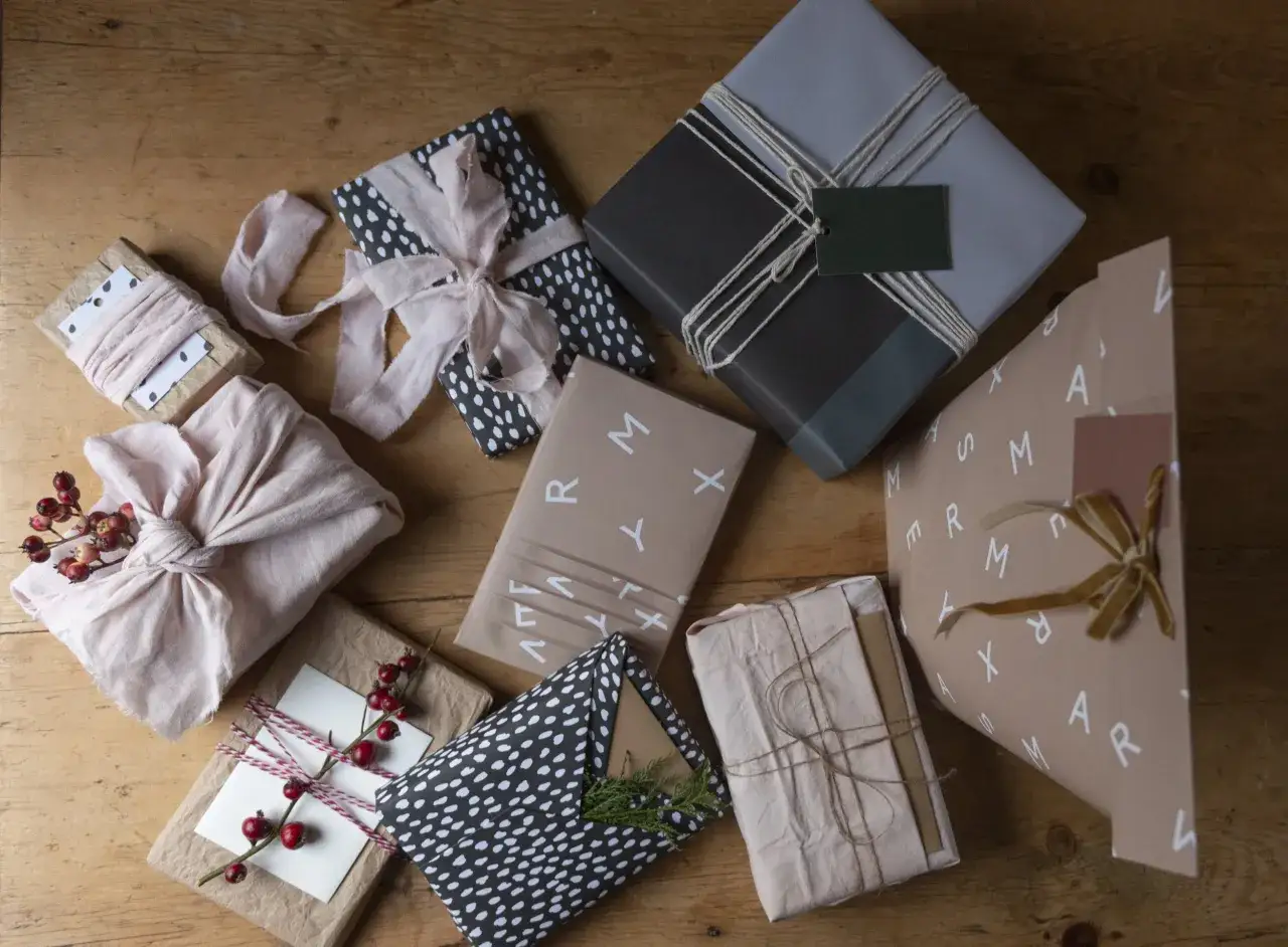 Mehrere Geschenke zusammen verpacken: liebevoll mit Stoff, Papier und B&auml;ndern umh&uuml;llt, bereit f&uuml;r die &Uuml;bergabe.