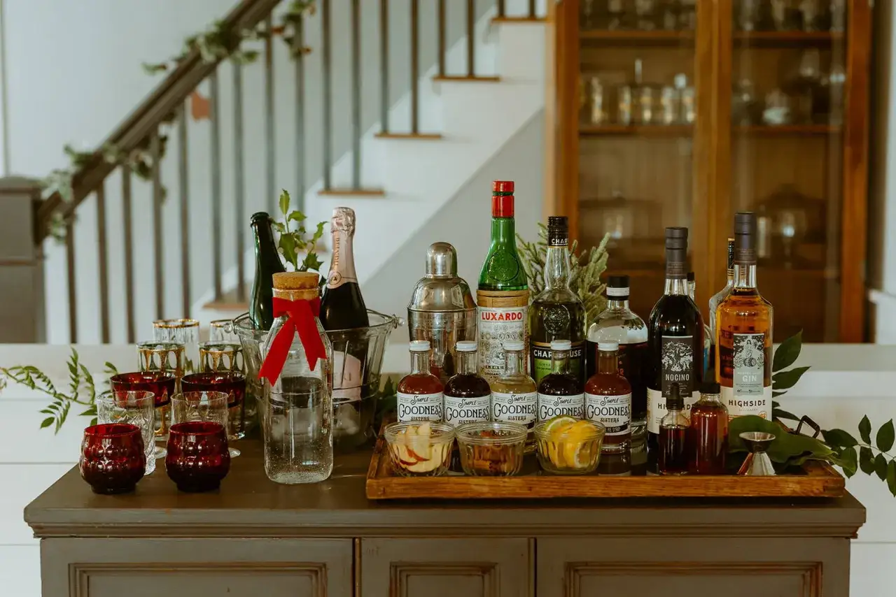 Bar mit verschiedenen Flaschen, Gl&auml;sern und Zutaten f&uuml;r Brandy Cocktails. Ein Shaker und kleine Fl&auml;schchen mit Lik&ouml;ren sind bereit.