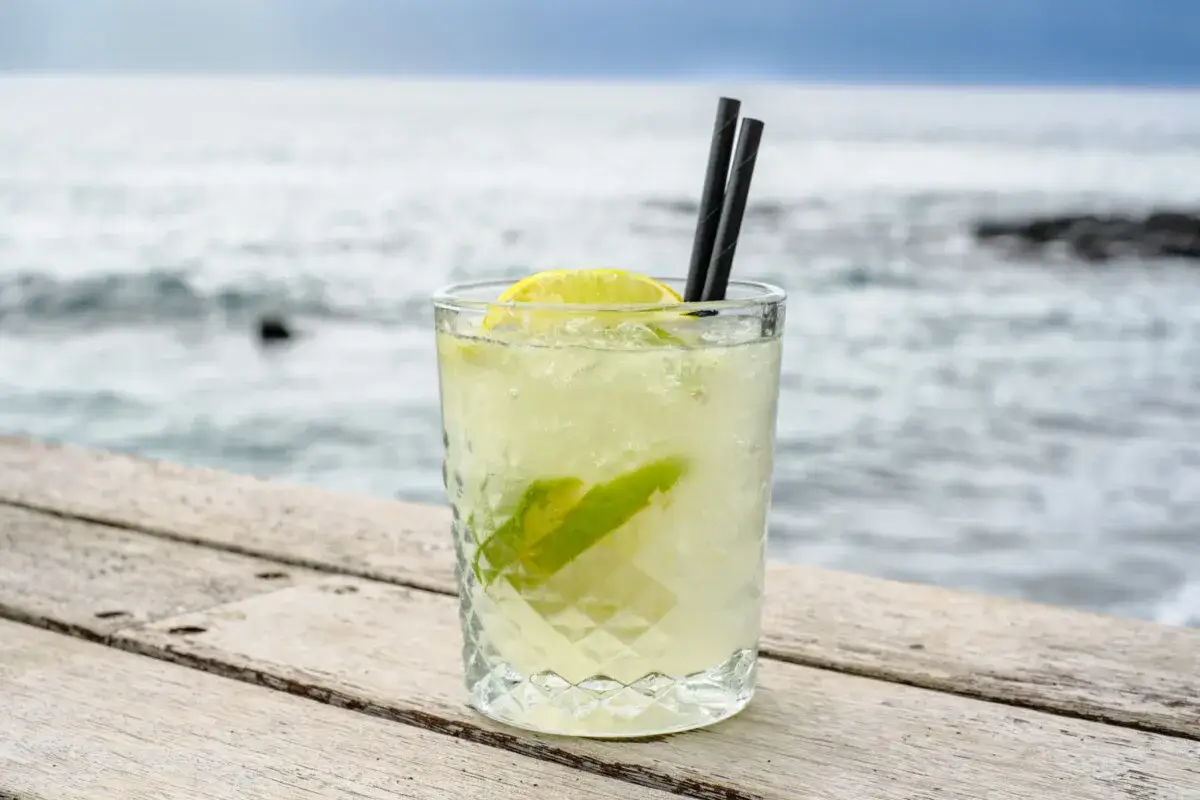 Erfrischender Caipirinha mit viel Eis, Limette und einem Hauch von Alkohol, serviert am Meer.