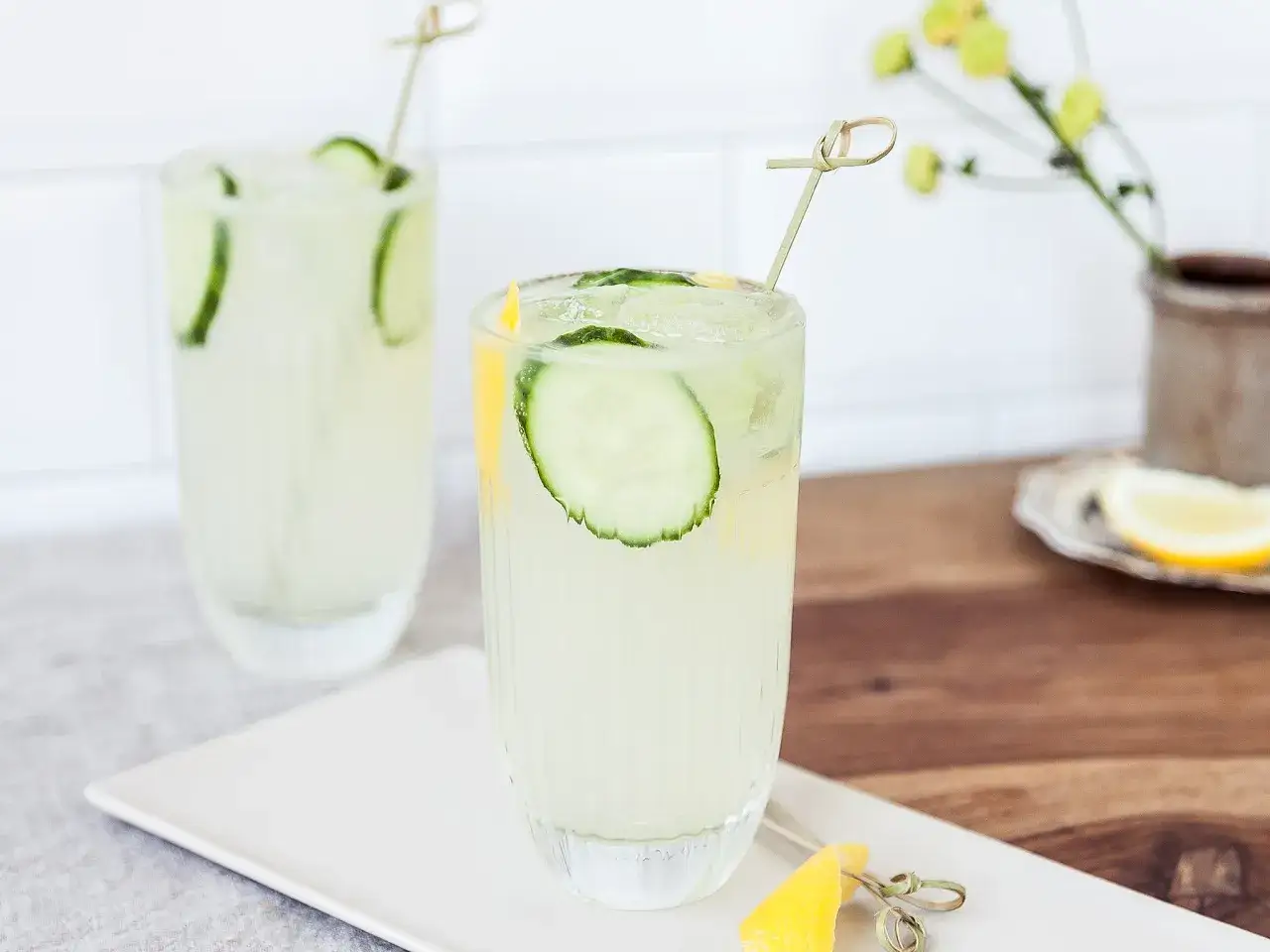 Erfrischender bitter lemon cocktail mit Gurkenscheiben und Zitronenspalten, garniert mit einem Holzspieß.