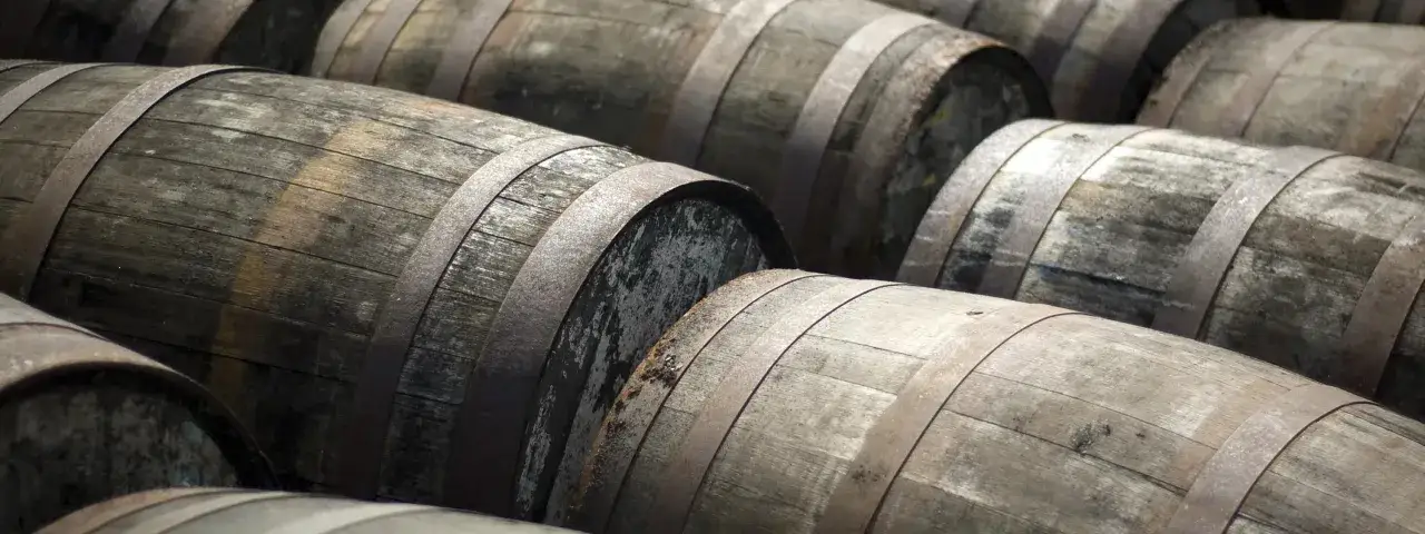 Reihen von alten Holzfässern, die darauf warten, dass ihr Whisky oder Whiskey reift.